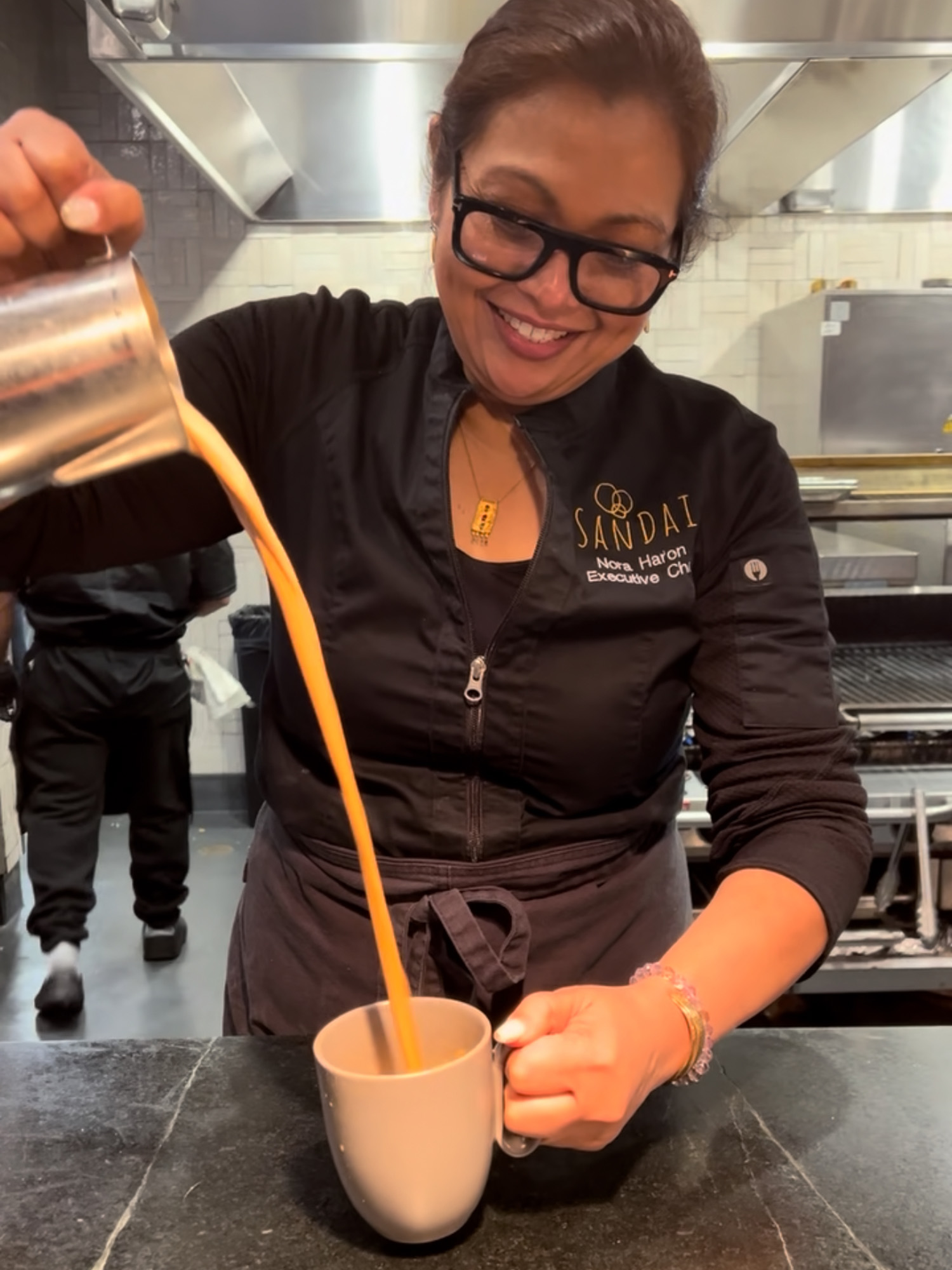Woman pours coffee into a cup from a great height.