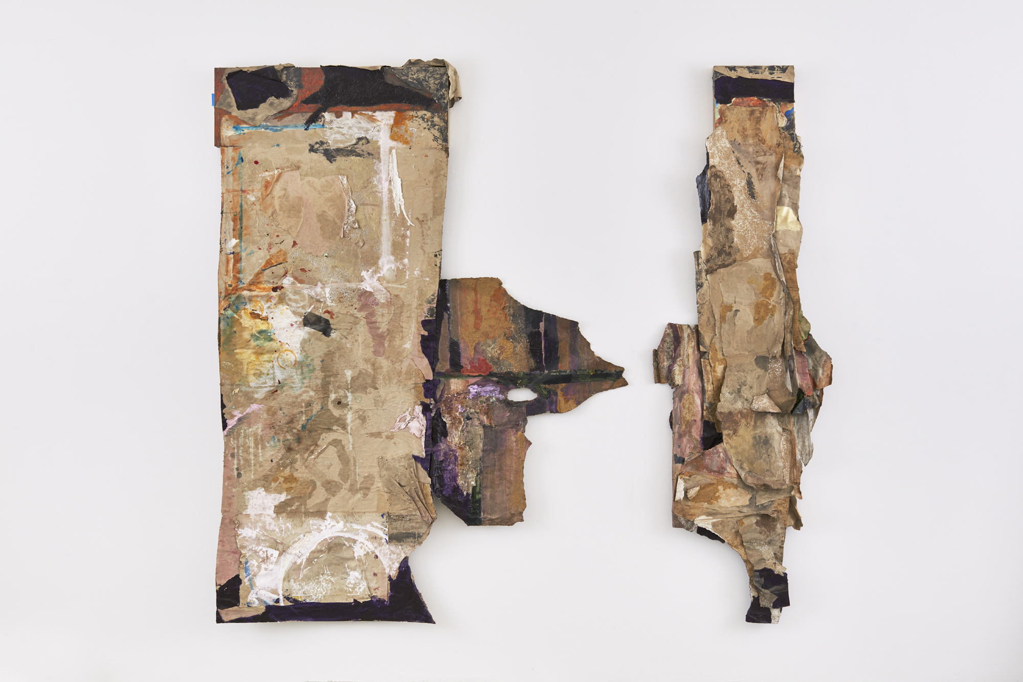 two rough-edged crinkled paper works on wall
