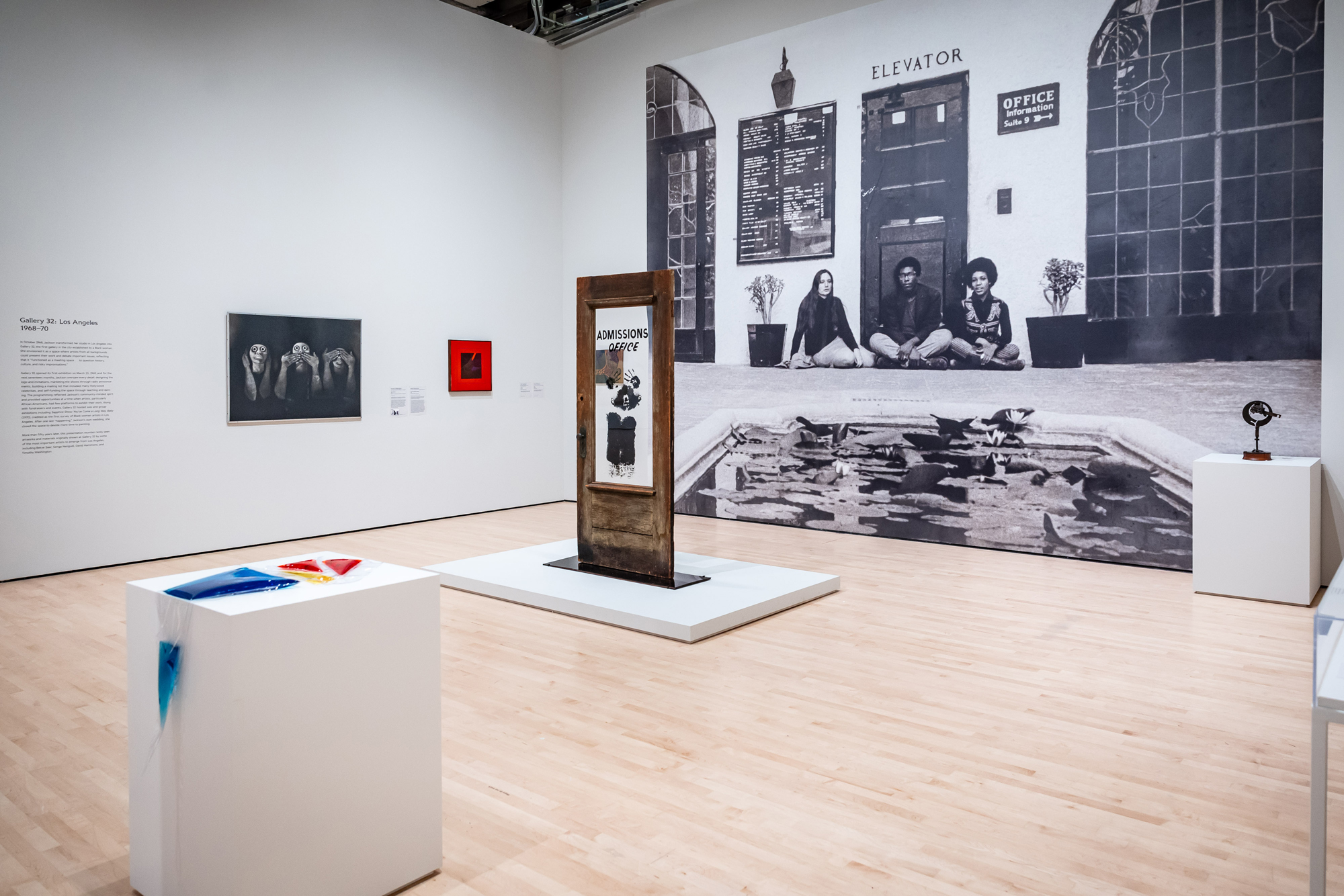 gallery view with large photo covering one wall, sculpture and framed work