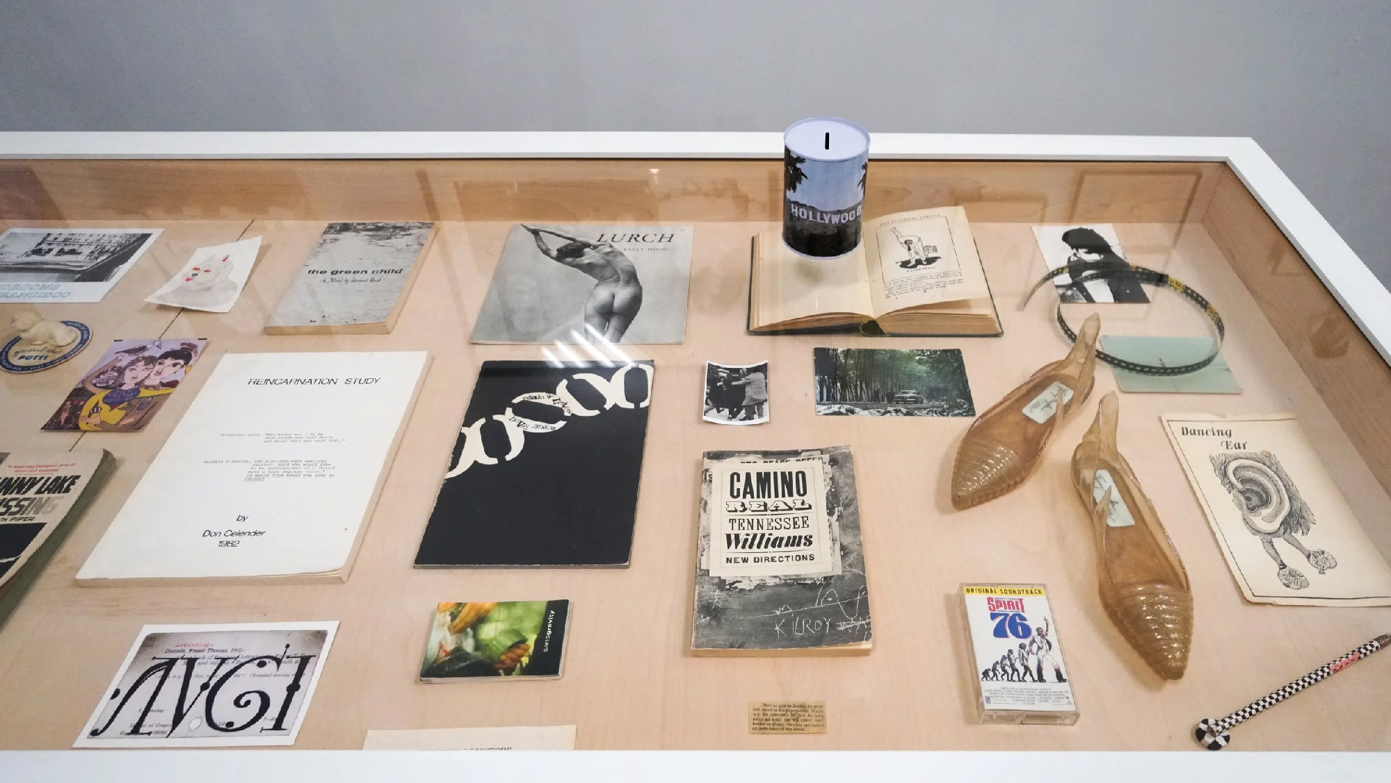 books, prints, shoes and other objects on display in vitrine