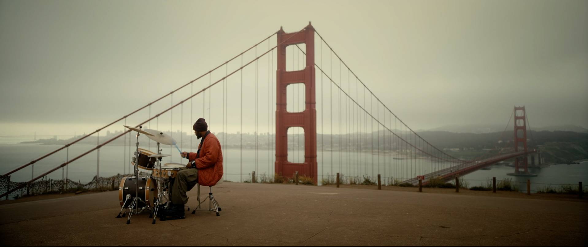 A drummer plays overlooking the Golden Gate Bridge.
