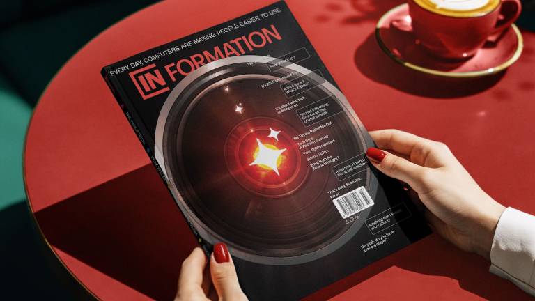 A magazine cover depicting the close up of a camera lens, its center burning red with light.