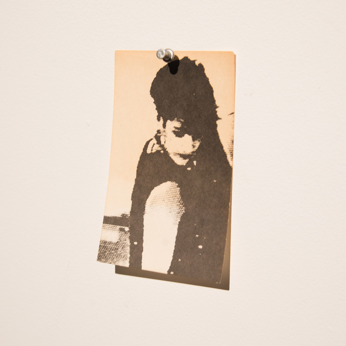 black and white image of person with short hair push pinned to wall