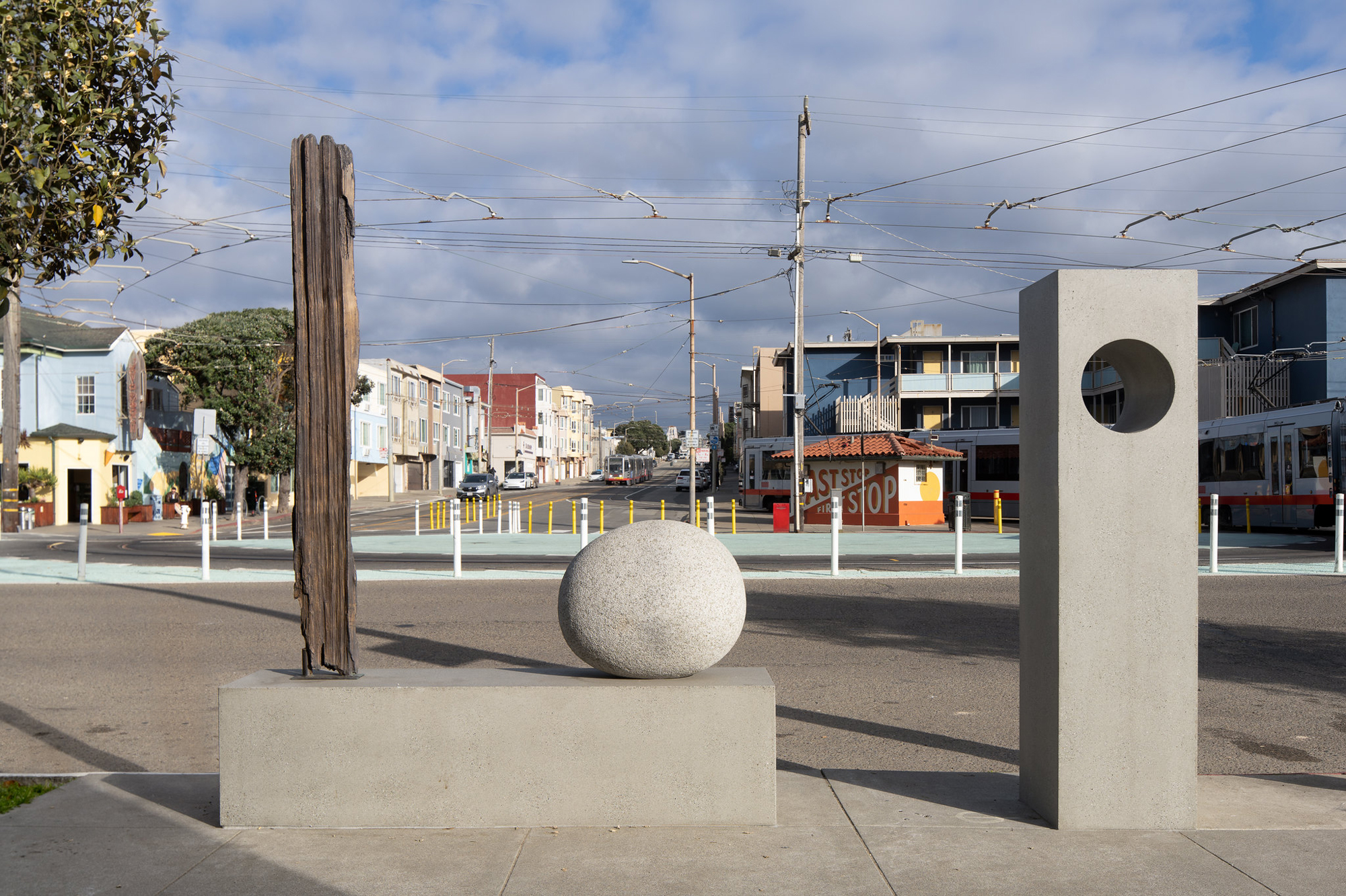 cast bronze driftwood, round stone and concrete plinths on city street