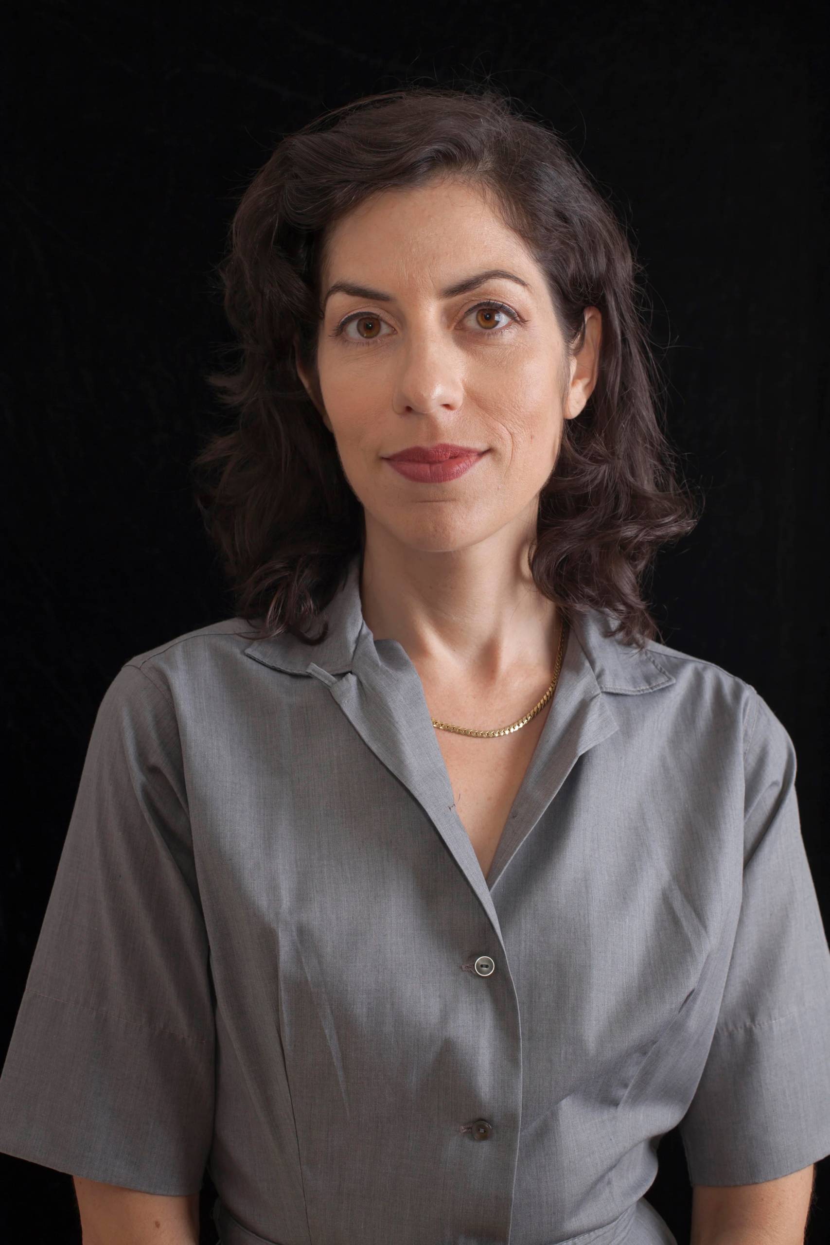 white woman with shoulder-length brown hair in gray shirt