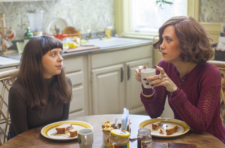 teenage girl and woman sit at table with meal on plates