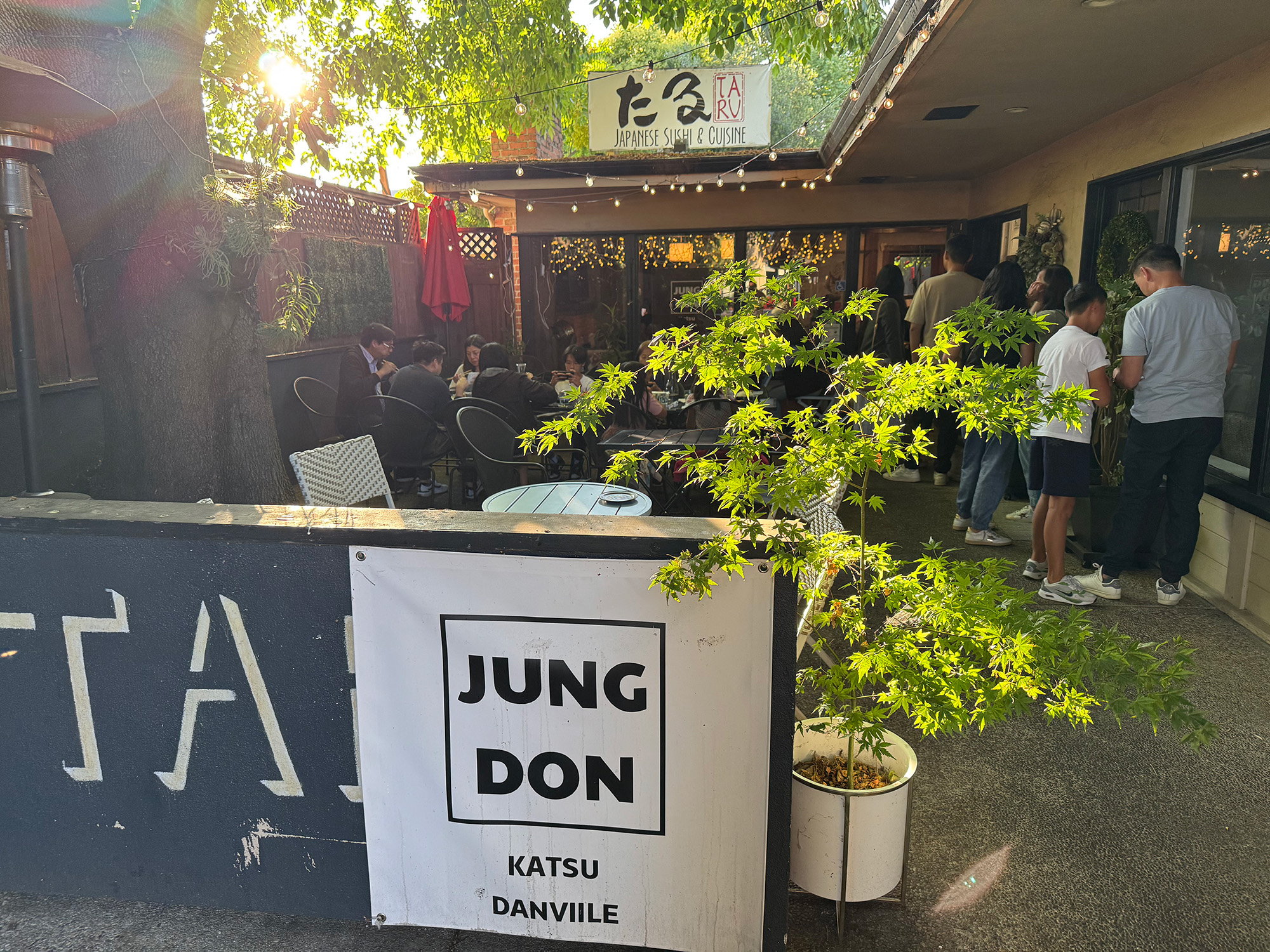 Exterior courtyard of a restaurant. The banner in front reads "Jung Don Katsu."