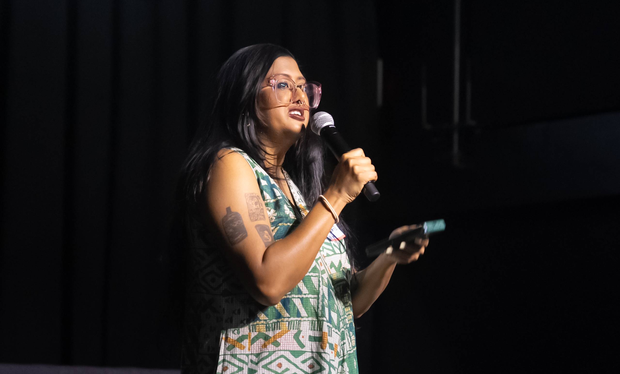 A person speaks into a microphone at a conference. 