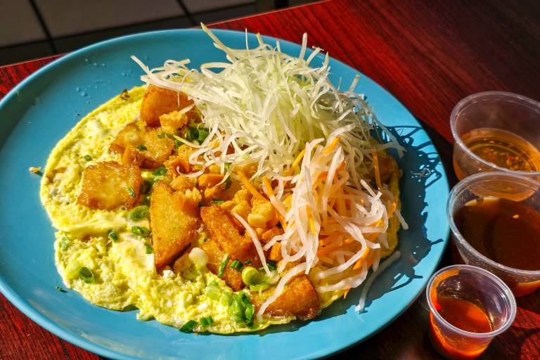 An egg omelette topped with crispy rice cakes and pickled carrots and daikon.
