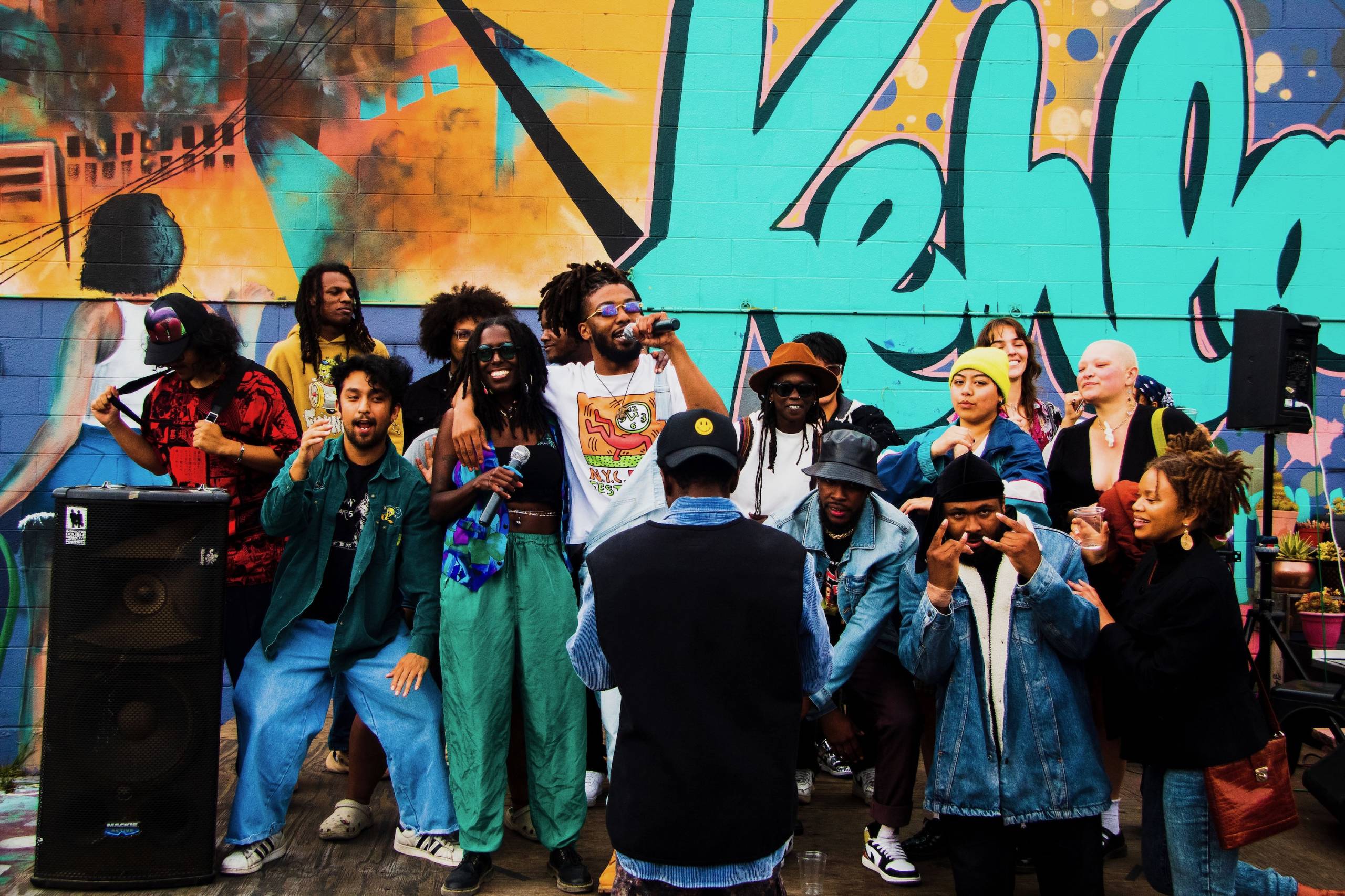 A group of people dance on stage during an outdoor hip-hop show.