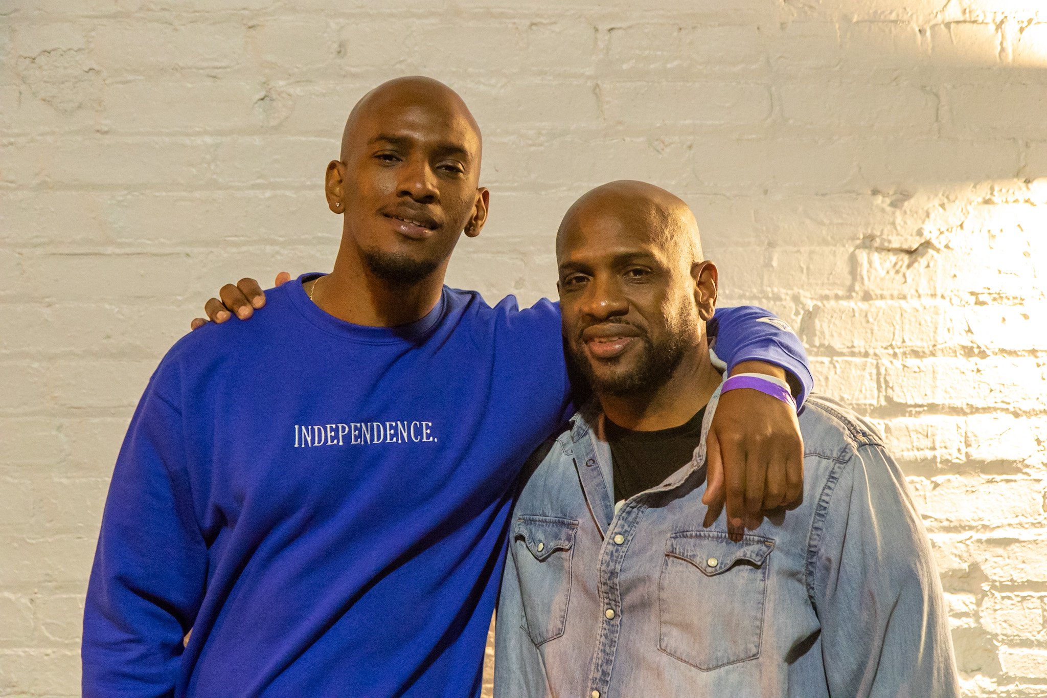 A father and his adult son put their arms around each other. 