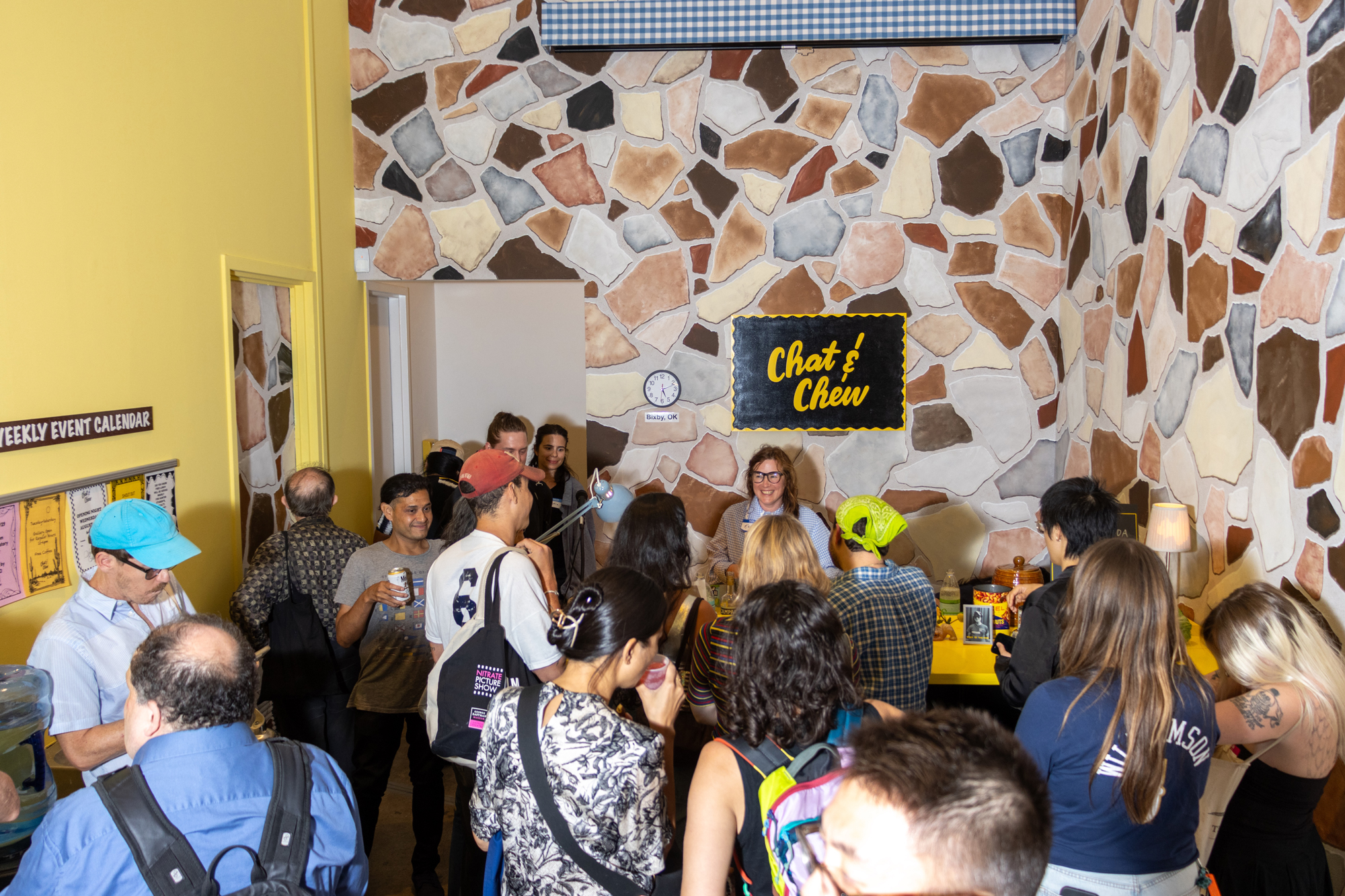 crowd of smiling people in faux rock painted corner
