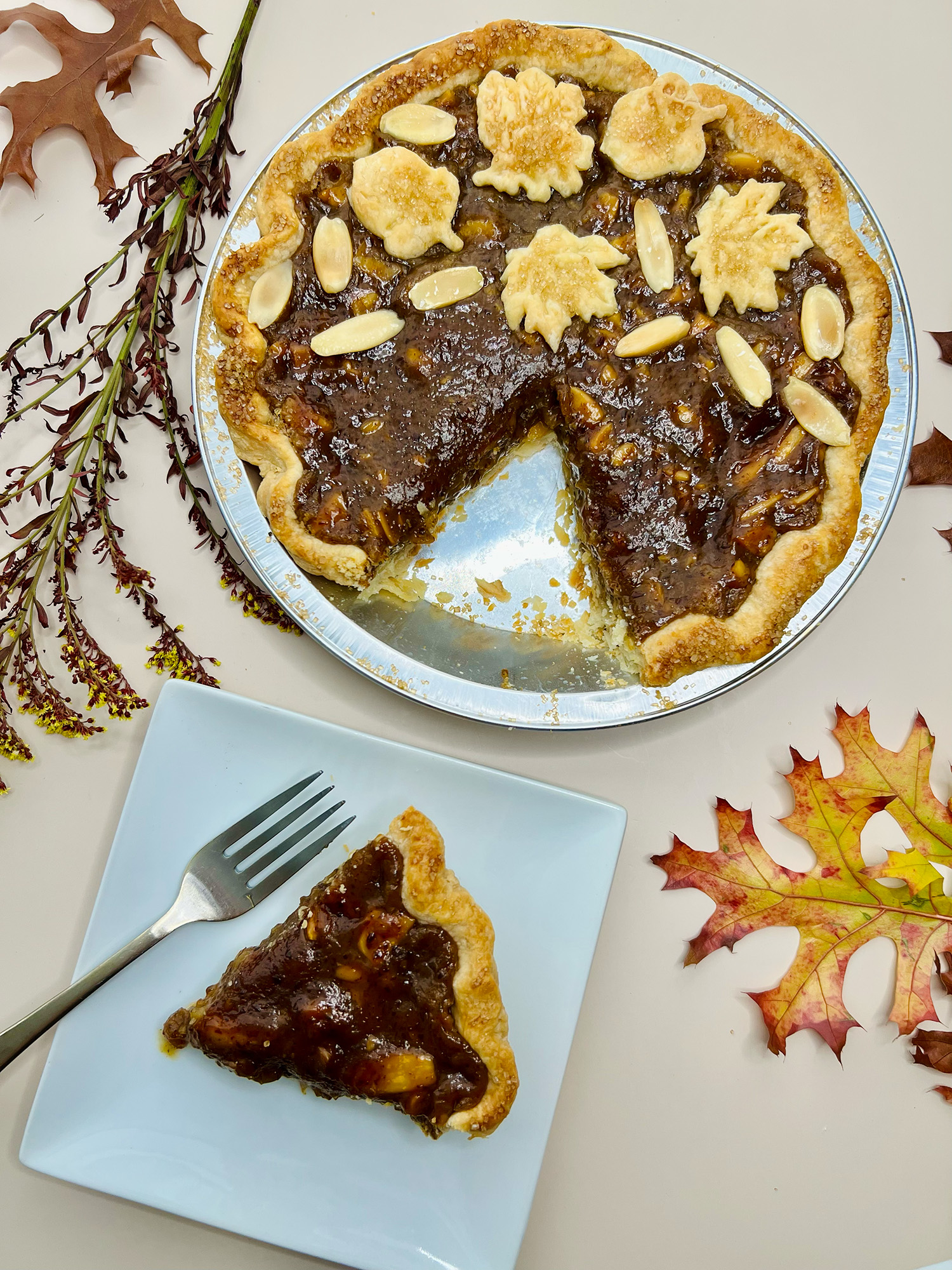 A caramel-y brown pie, with a single slice cut out and served on a plate.