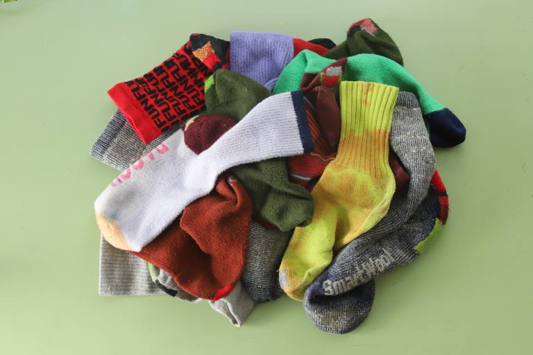 pile of colorful patched socks on green table
