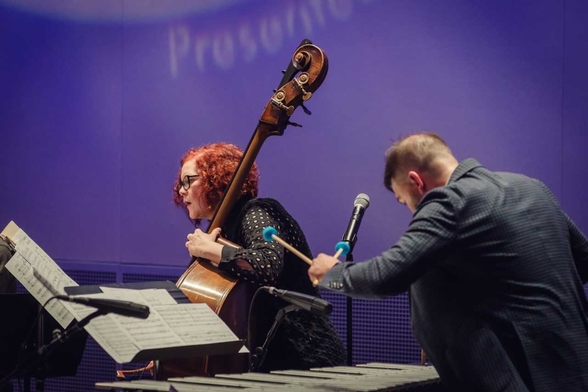 A candid shot of two people playing jazz on stage. 