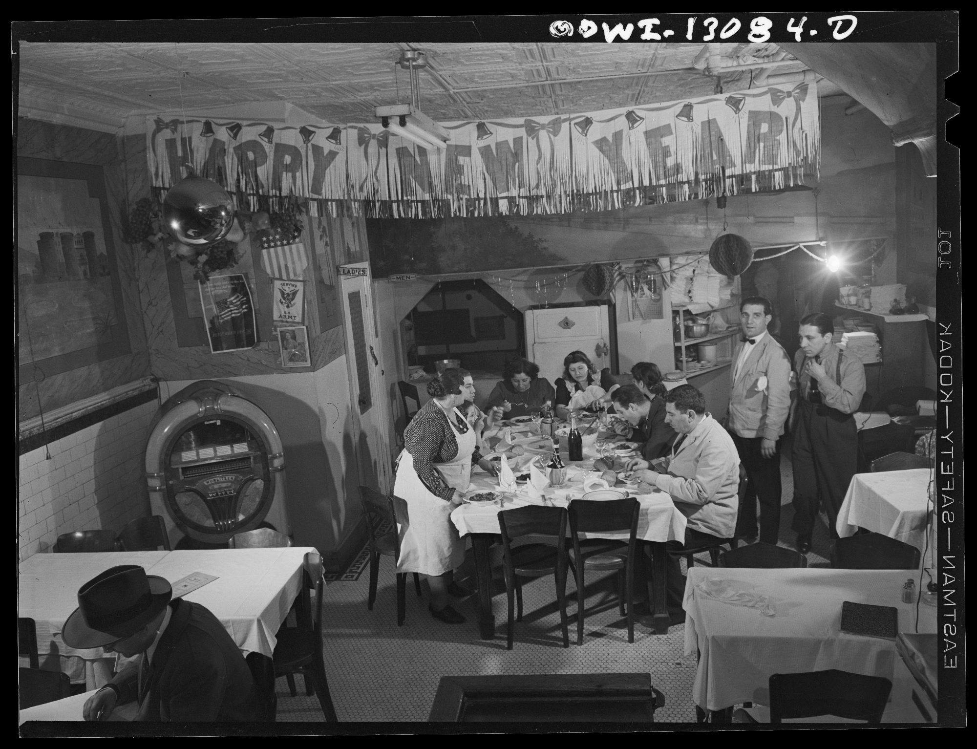 family seated at restaurant table under Happy New Year banner