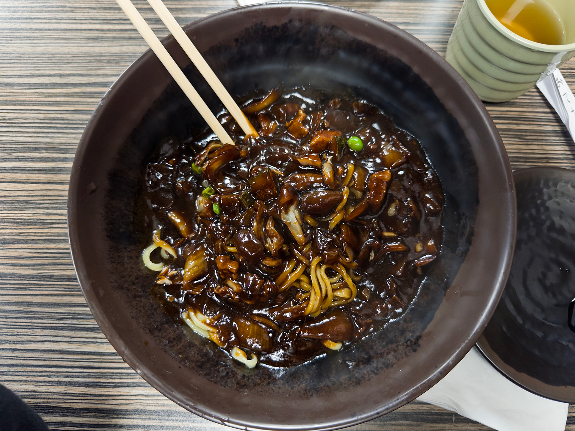 Overhead view of a bowl of Korean jjajangmyeon (black bean sauce noodles).