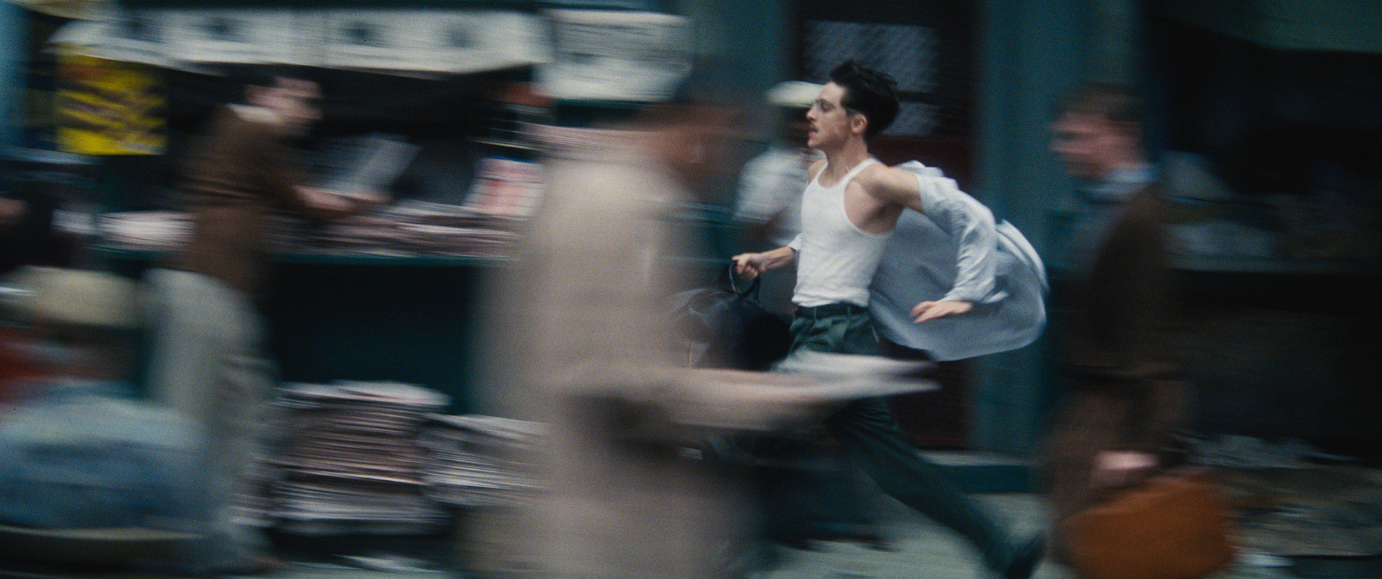blurry image of man running down busy city street with valise