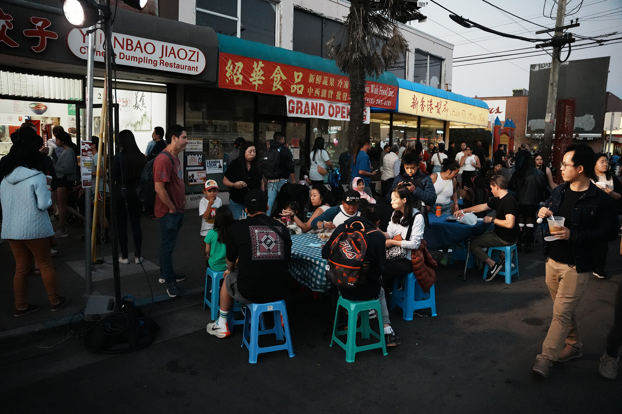 A crowd of diners seated outside a Chinese restaurant.