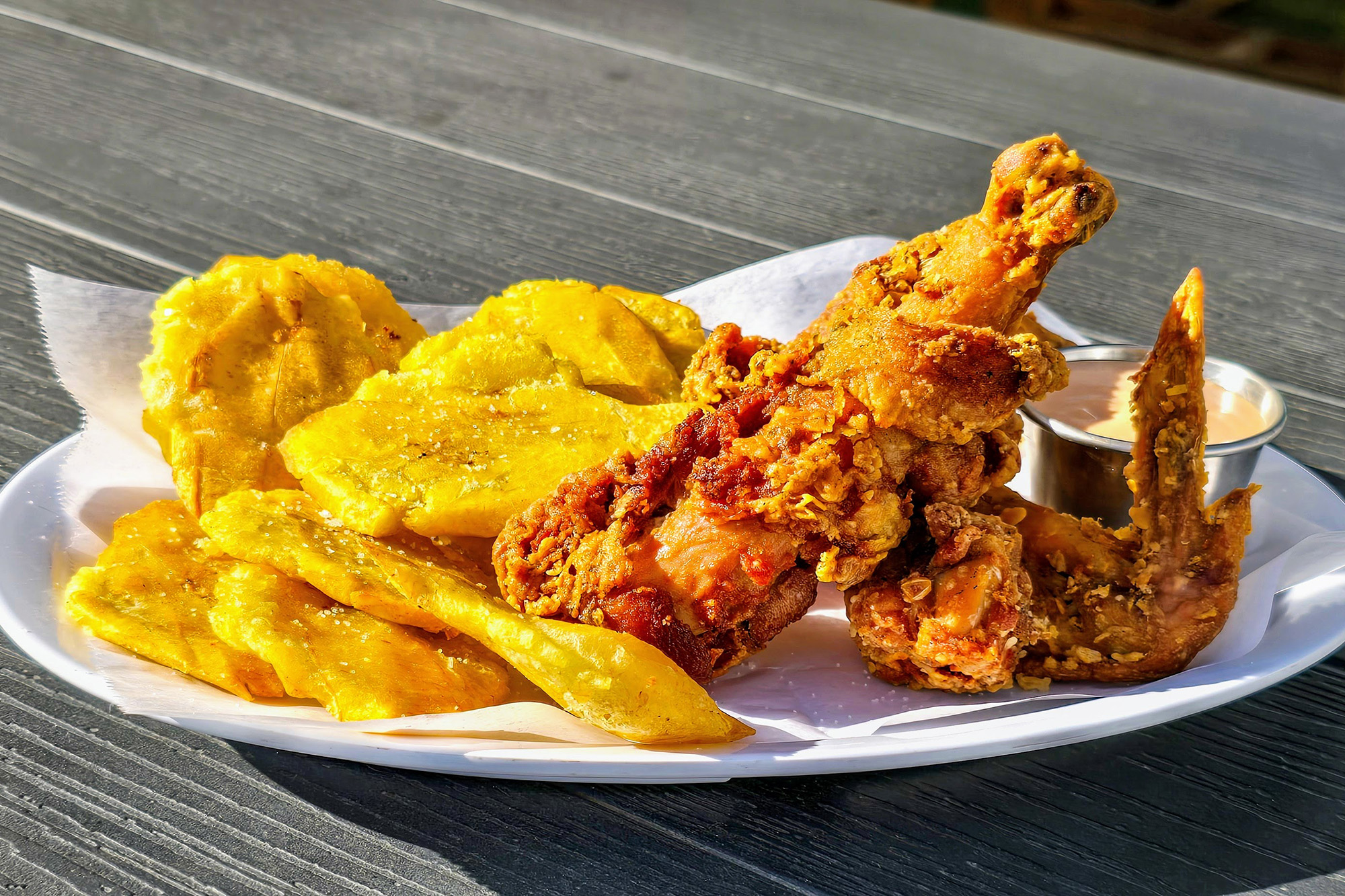 A plate of fried chicken and tostones.