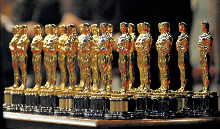 A table holding a cluster of shiny, gold academy awards.