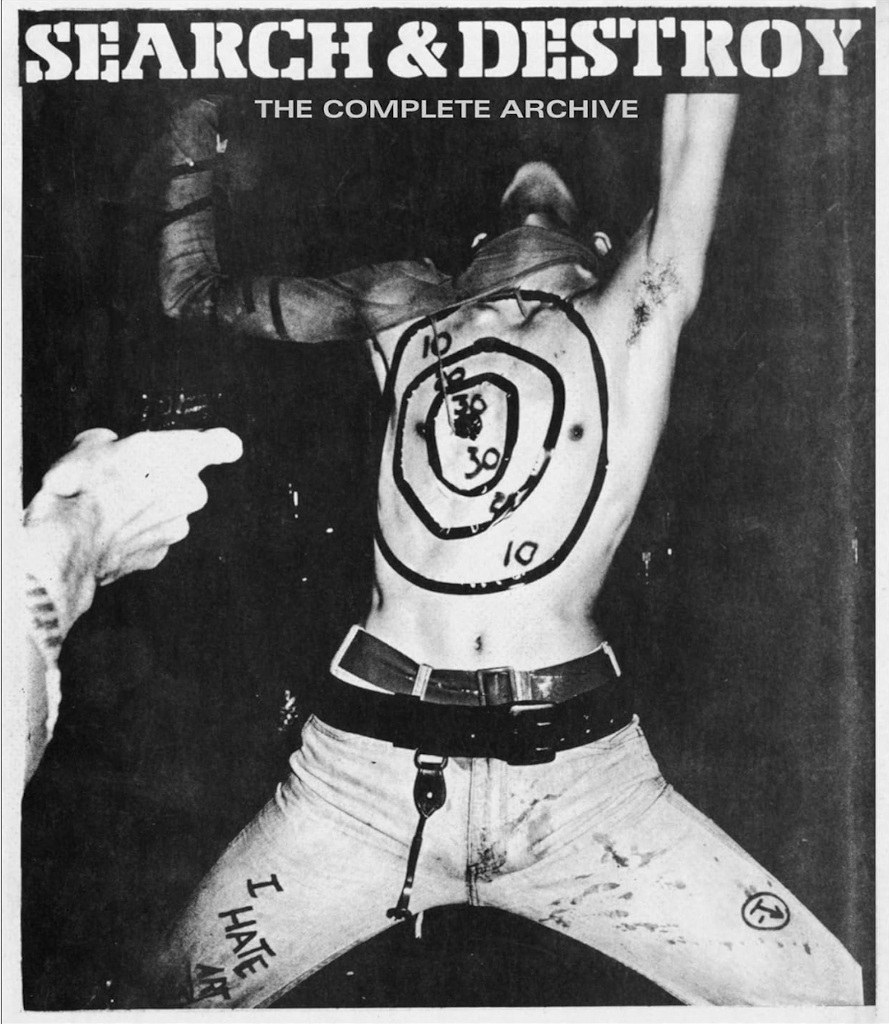 A book cover featuring a black and white photograph of a thin, white man, performing on his knees, his face obscured, with a target drawn on his shirtless torso. An audience member's arm reaches out with their hand positioned as if pulling a trigger.