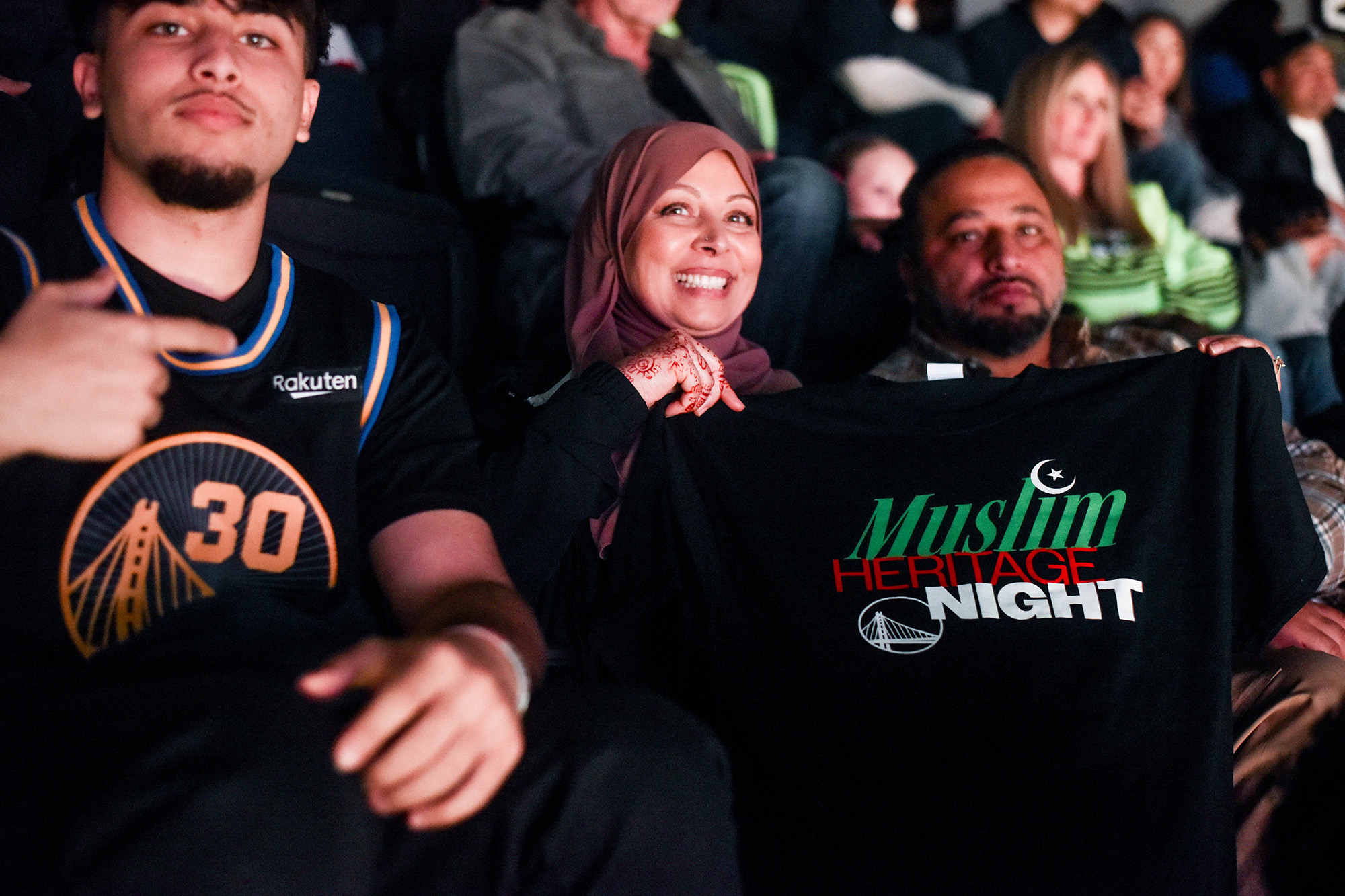 Warriors' fans hold up a "Muslim Heritage Night" T-shirt.