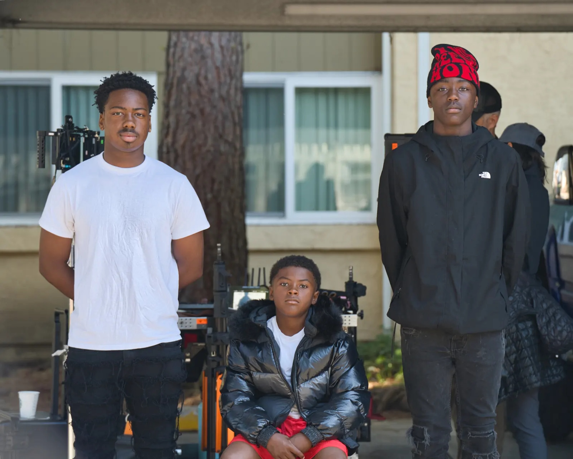 Three African-American men pose for a photo on the set of a short film. 