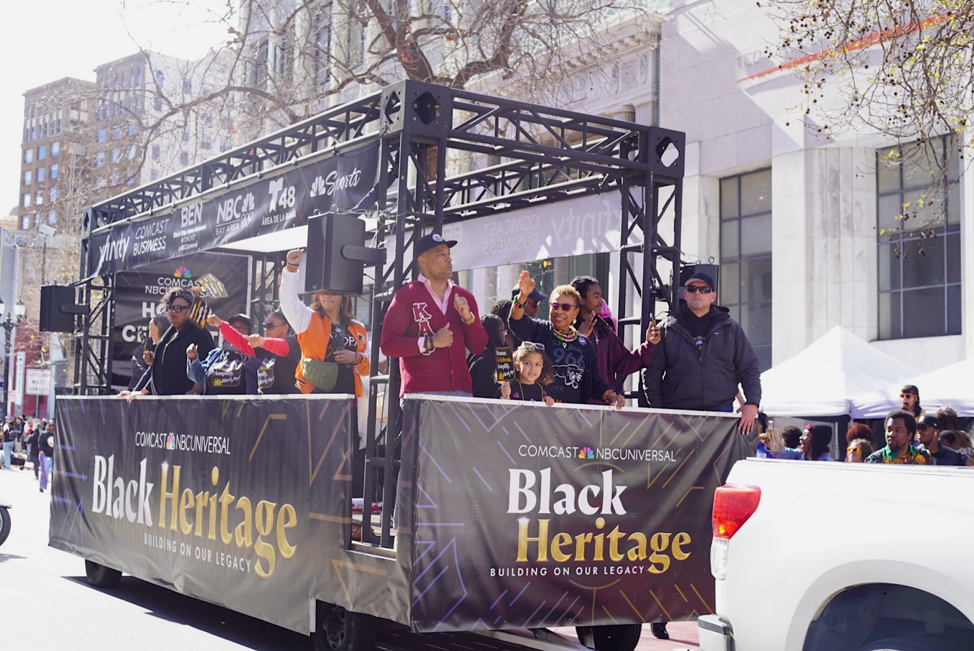 A float full of people coasts down a main street in during a parade. 