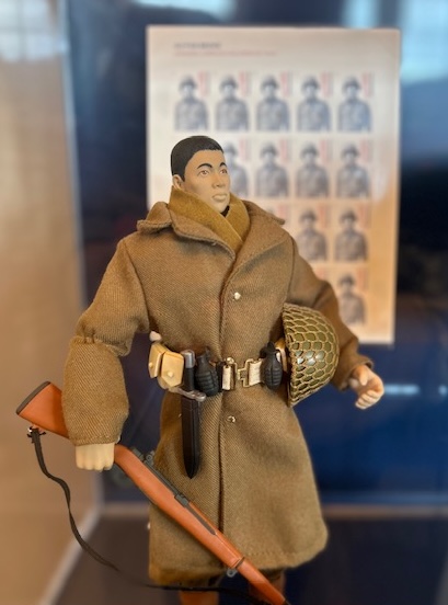 A 1940s-era Japanese G.I. Joe, complete with rifle, helmet and tool belt, inside a display case.