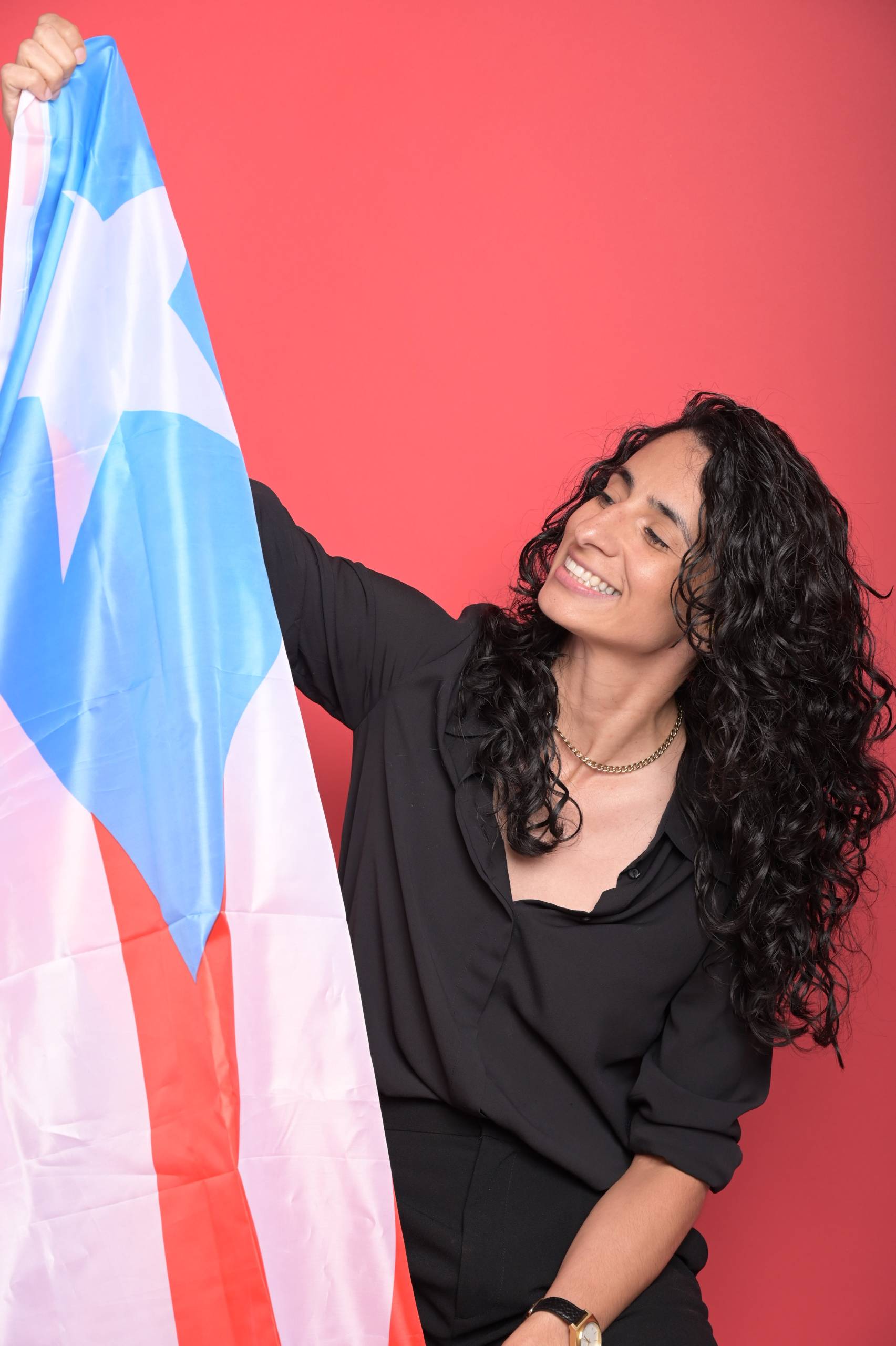 A woman holds up a Puerto Rican flag.