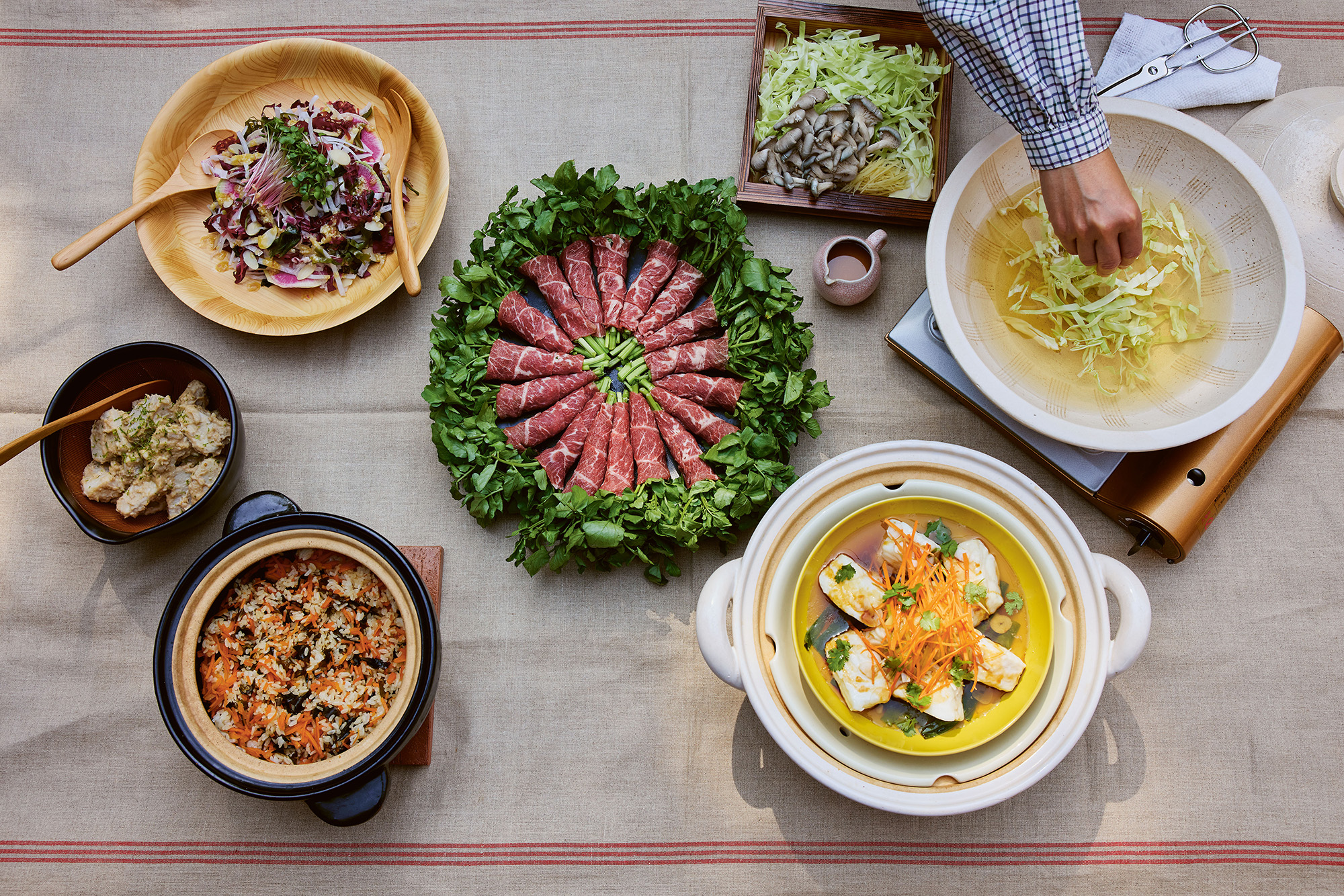 A spread of meat and seafood, ready to be cooked in a donabe for a hot pot meal.