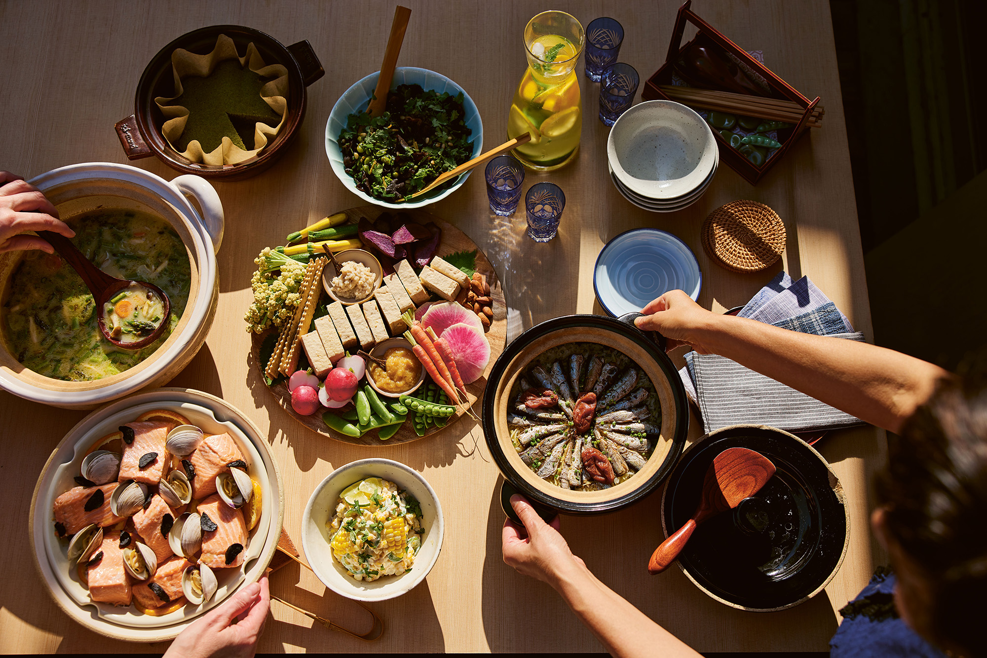 A spread of seafood dishes cooked in traditional Japanese clay pots.