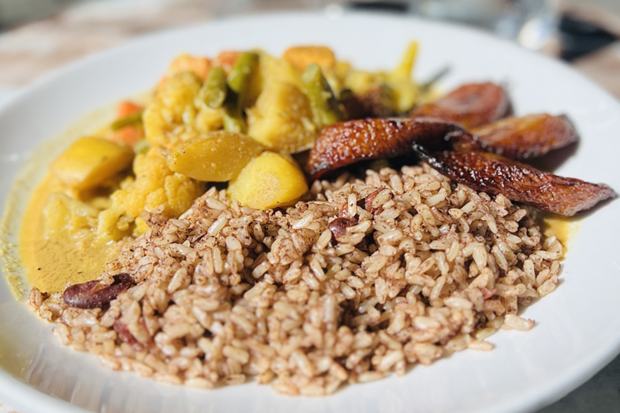 A plate of Jamaican rice and peas with vegetable curry.