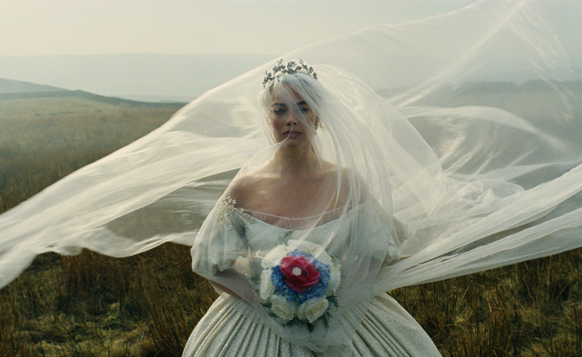 An unhappy bride walks the English moors, bouquet in hand, veil blowing wildly in the wind.
