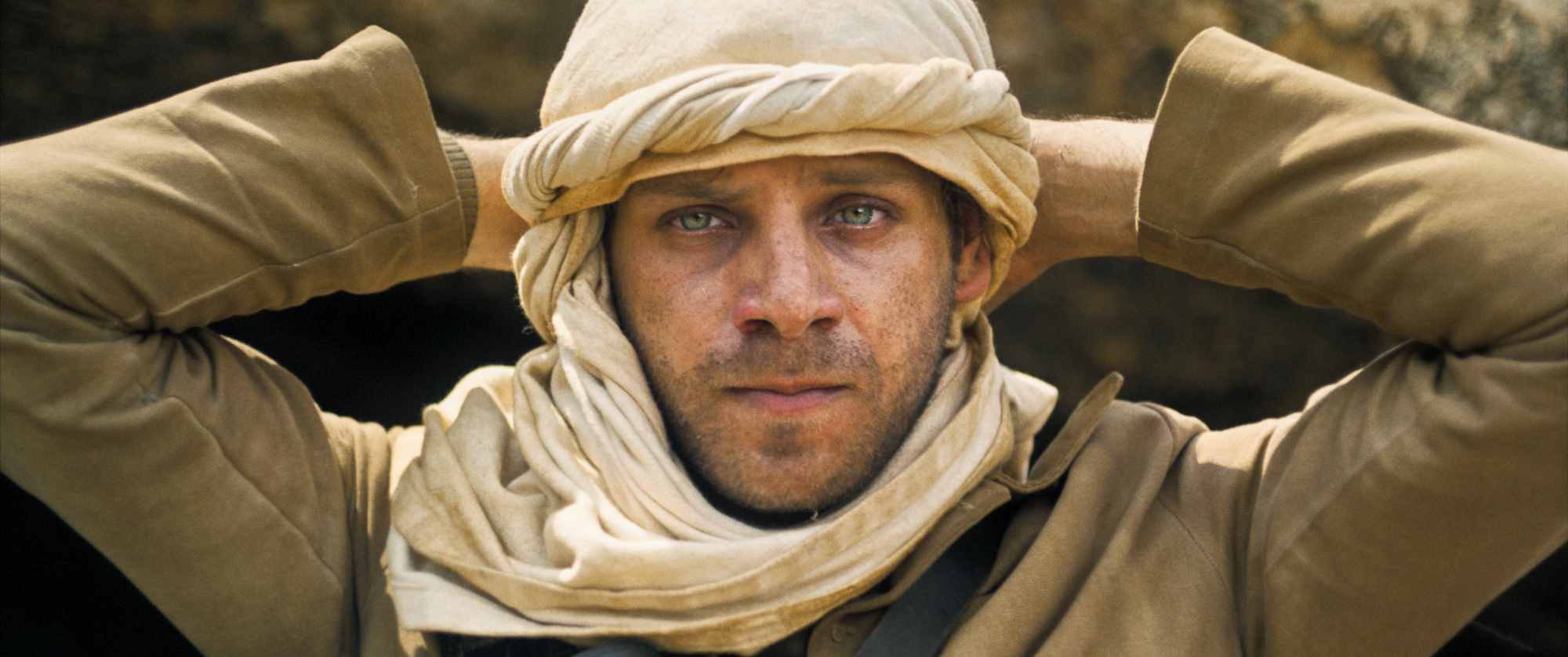 man in turban with hands behind head and tears in eyes