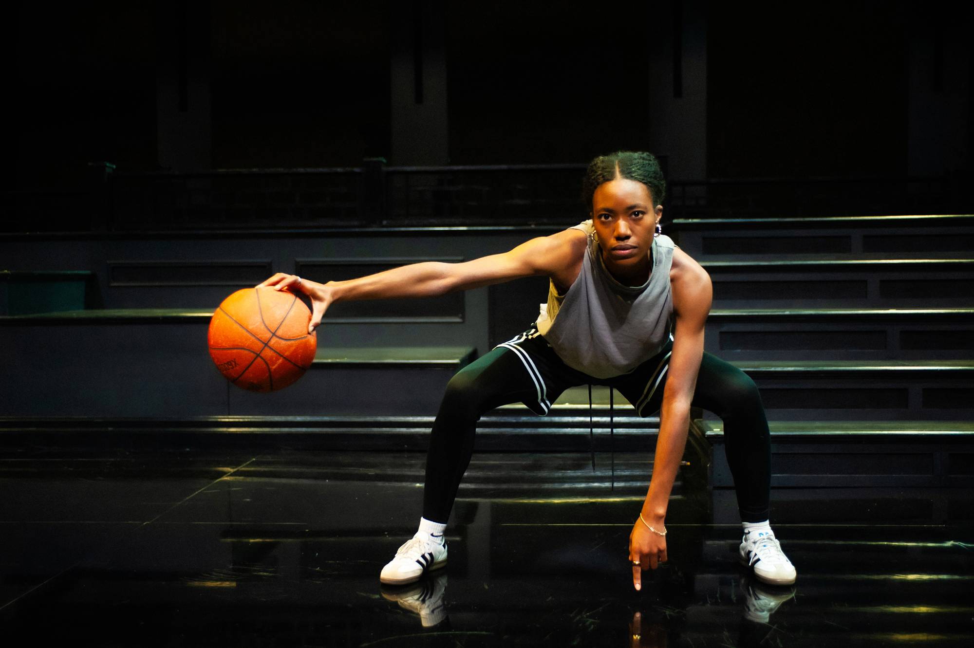A young woman palms a basketball.