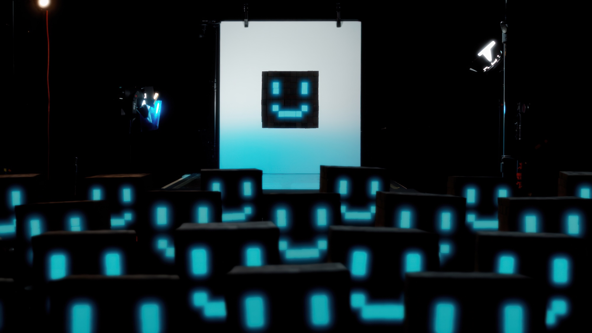 A screen crowded with small black boxes with blue smiling faces. They are identical and clustered together with one hovering over them in the center.