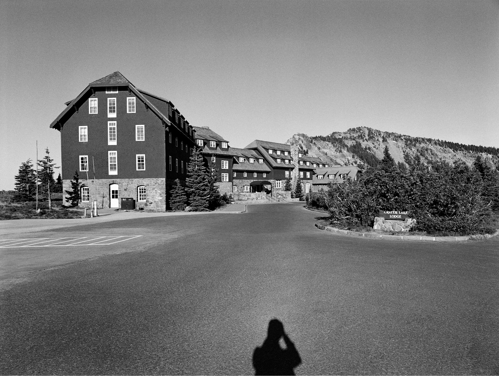 black-and-white photo of hotel building with photographer's shadow at bottom