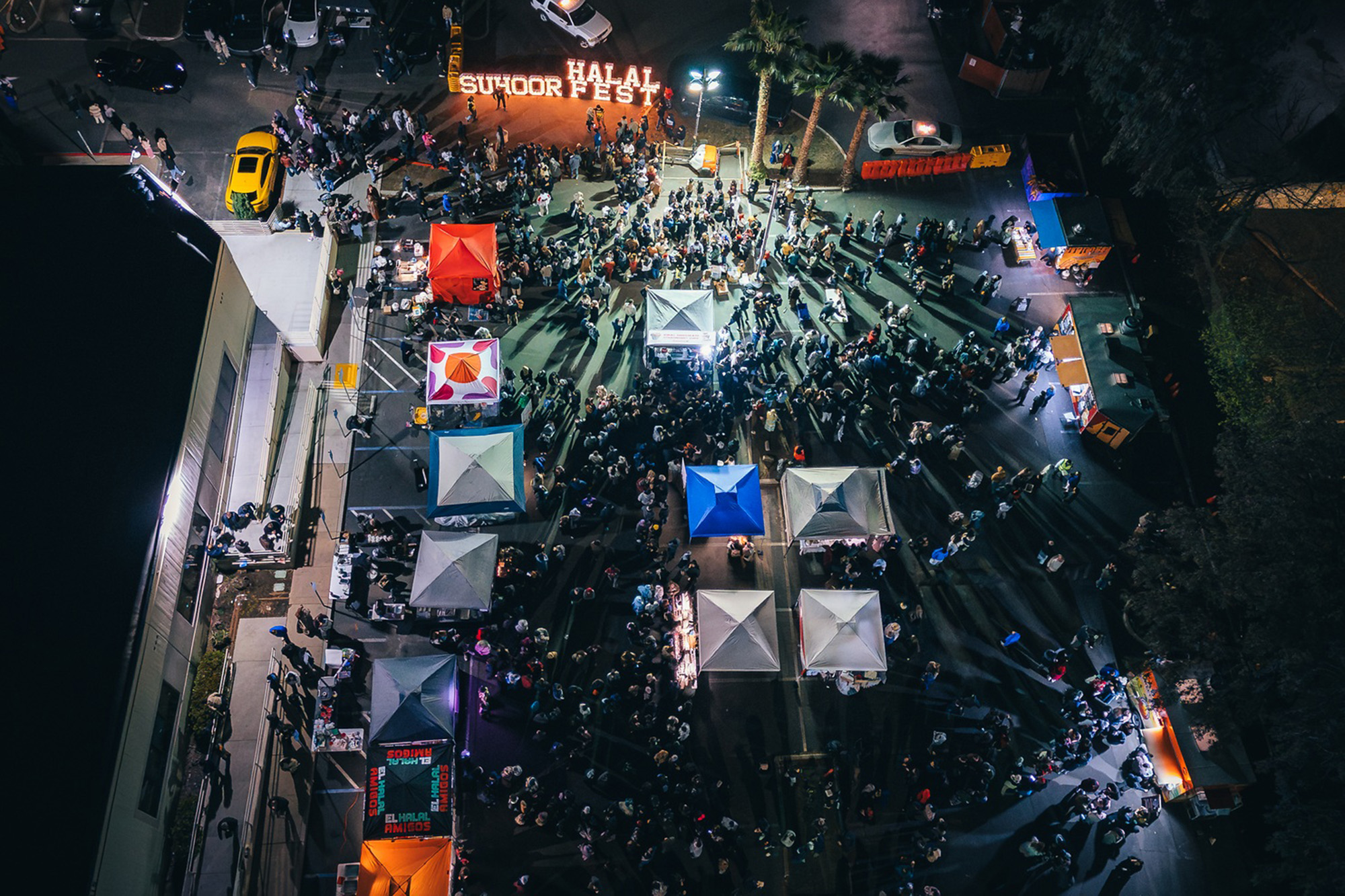 Overhead drone photo of a crowded festival at night.