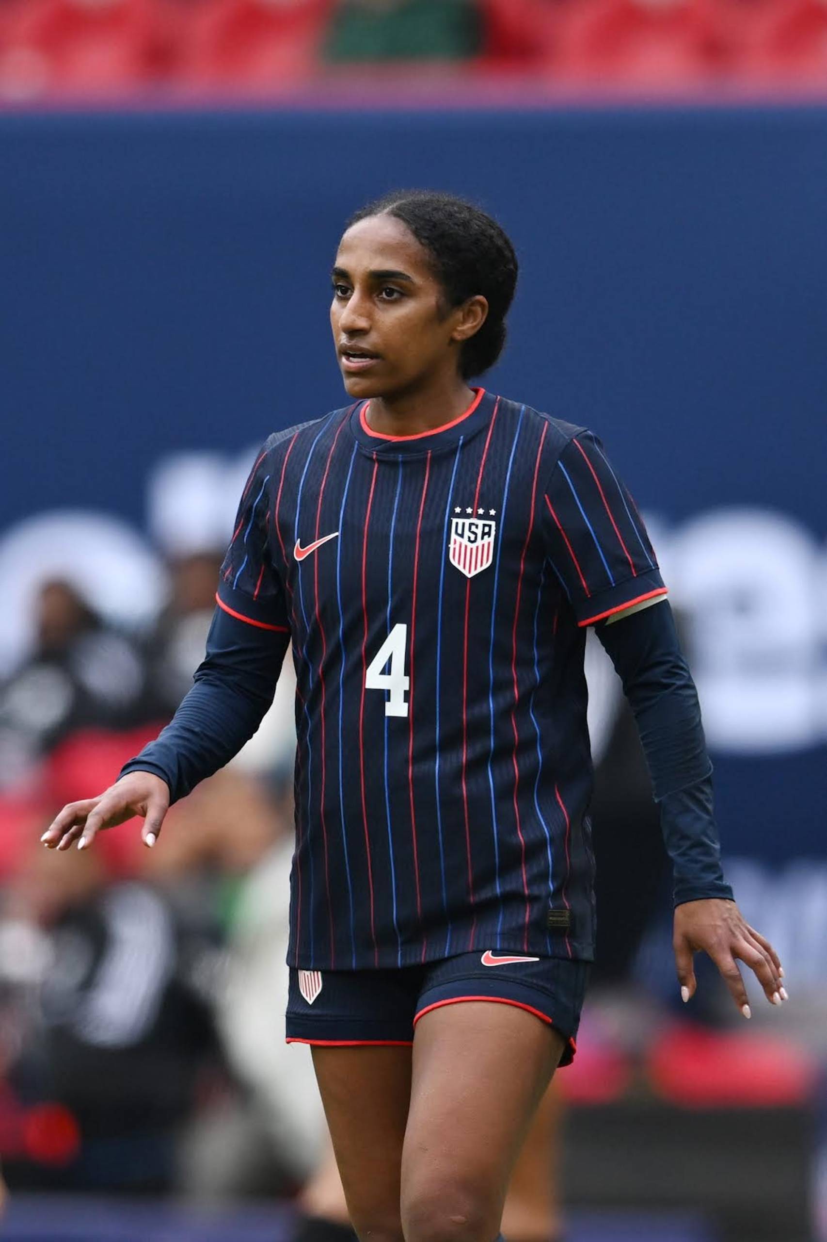 A candid photo of a woman in a team USA soccer jersey. 
