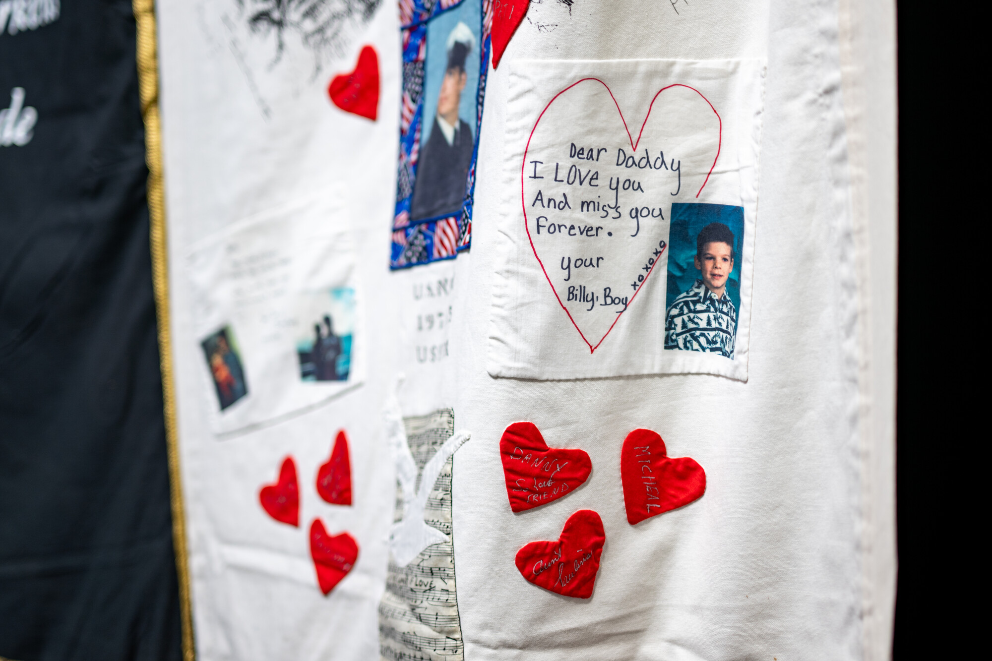 handwritten note from son to father on part of quilt, red hearts below