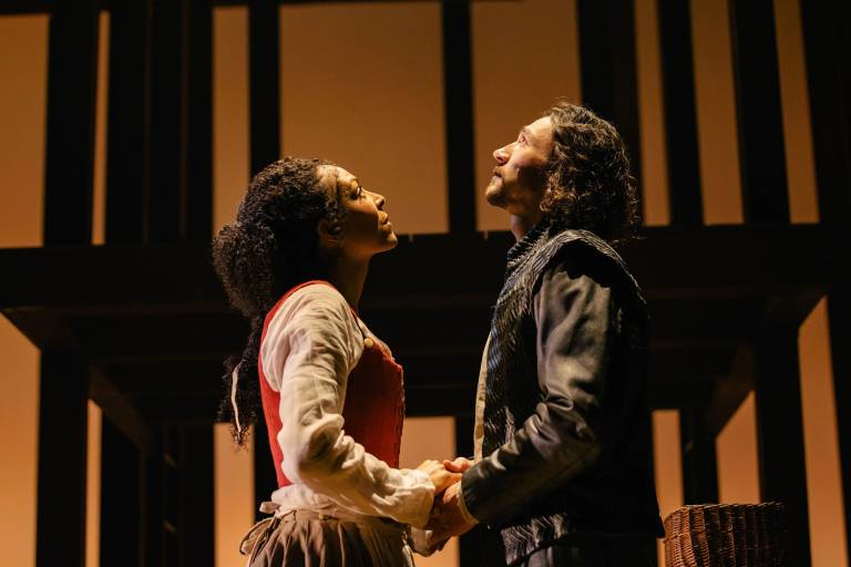 A man in blue and a woman with a flower crown look upward