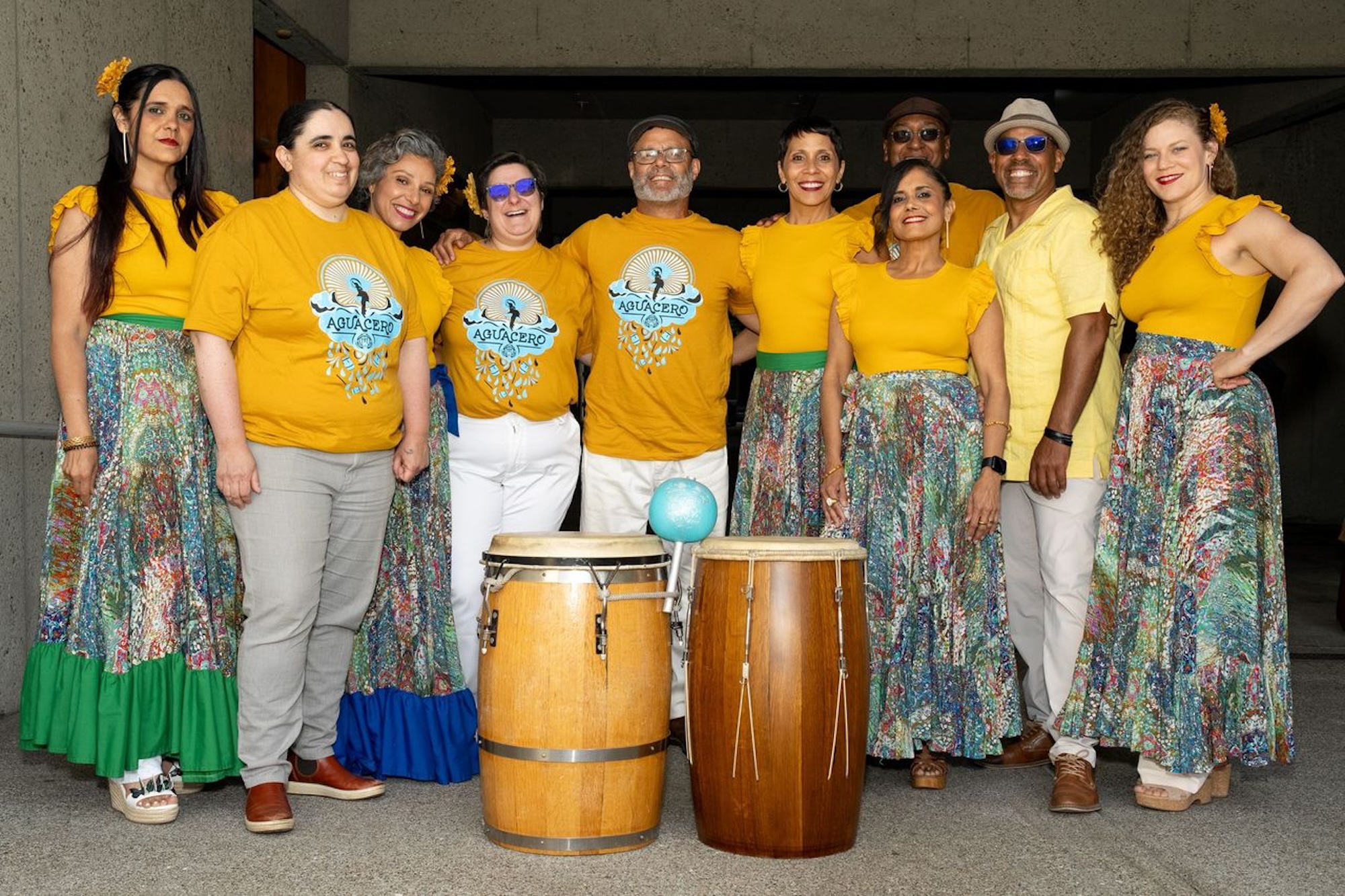 Members of a bamba ensemble pose for a photo while wearing coordinated yellow shirts. 