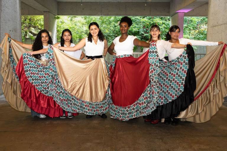 Six young women pose while wearing bomba attire.