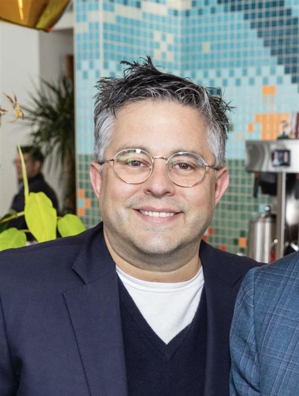 white man with glasses smiles