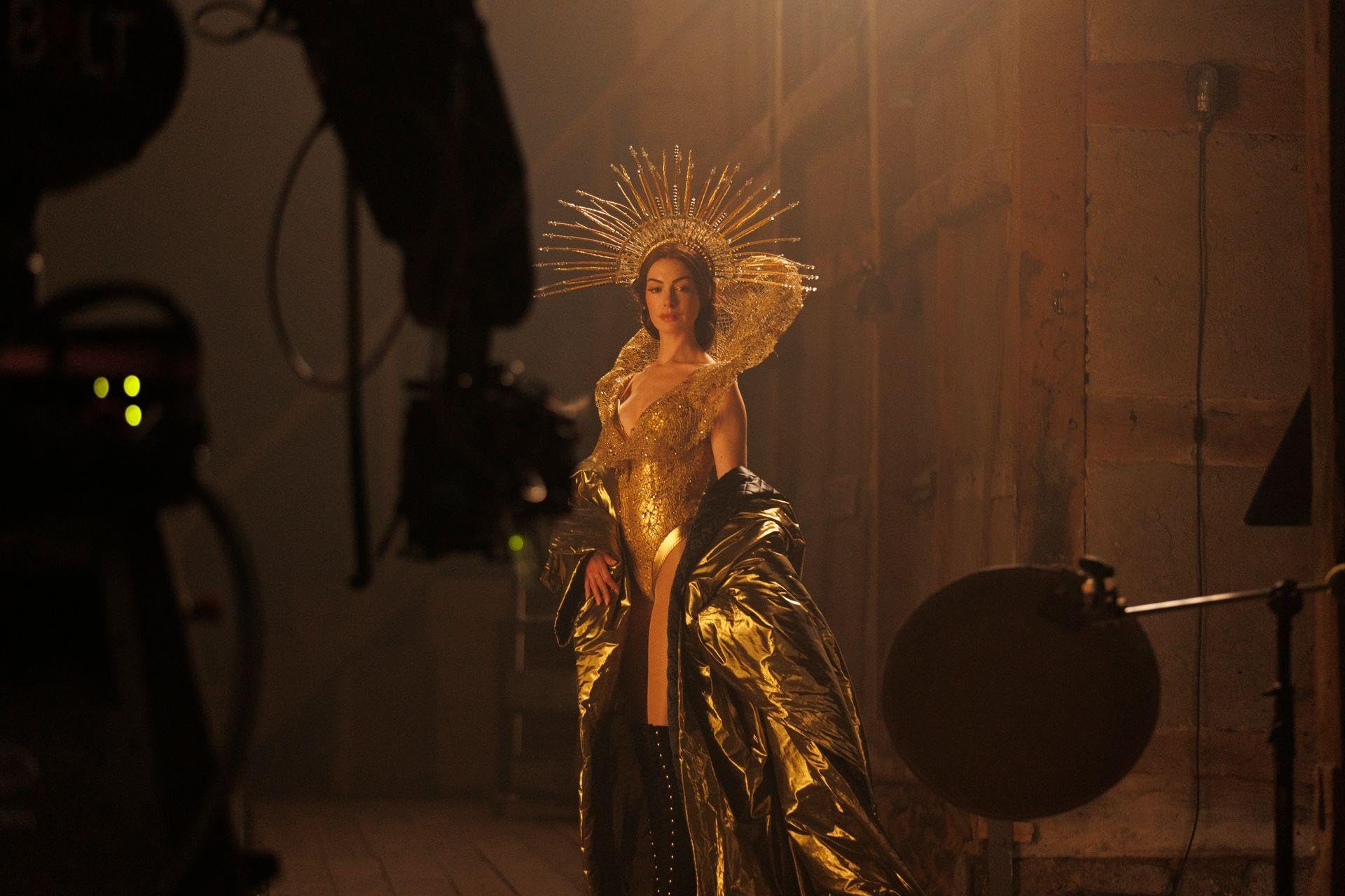 Anne Hathaway pictured in a gold outfit and headpiece.