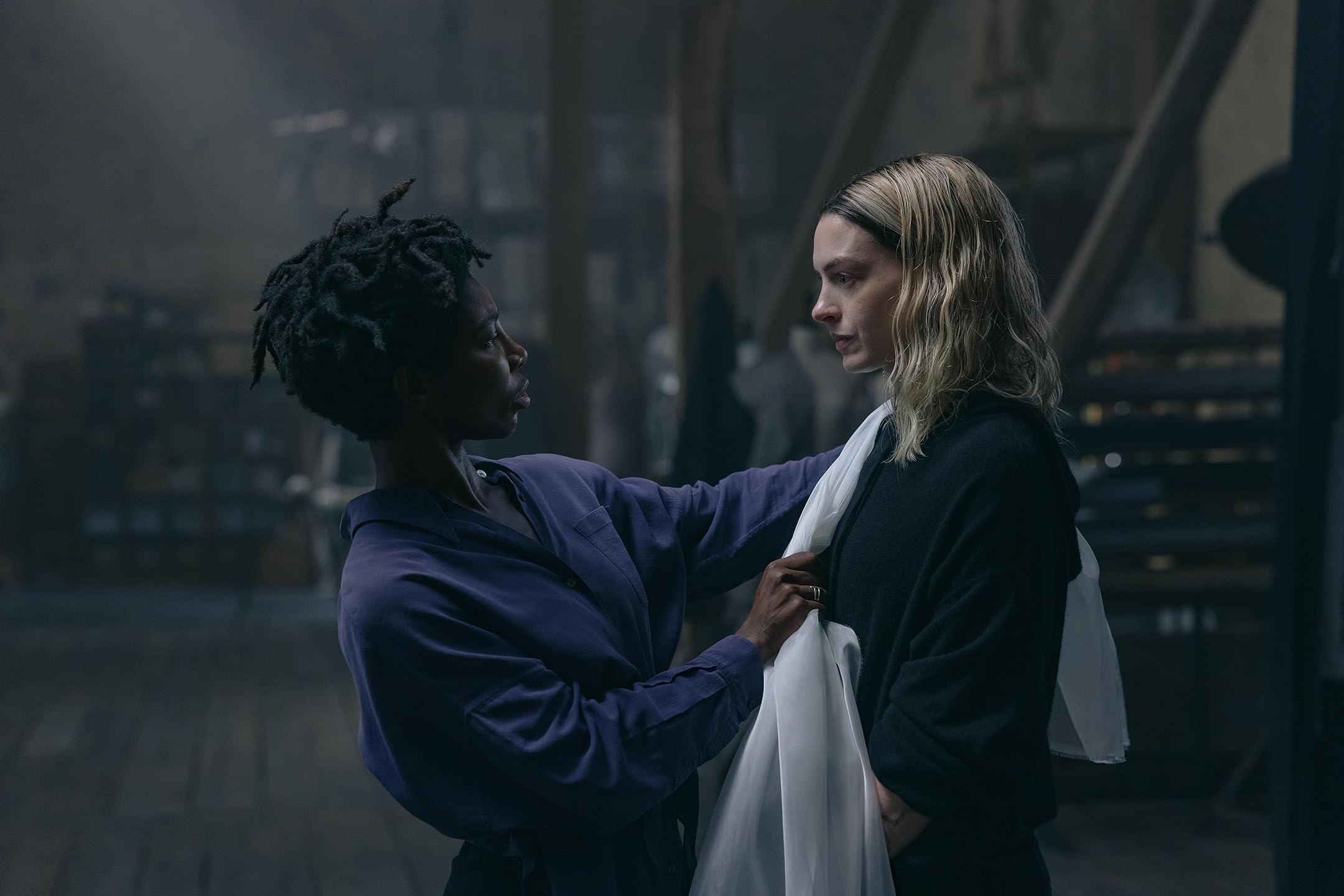 Two women stand facing each other.
