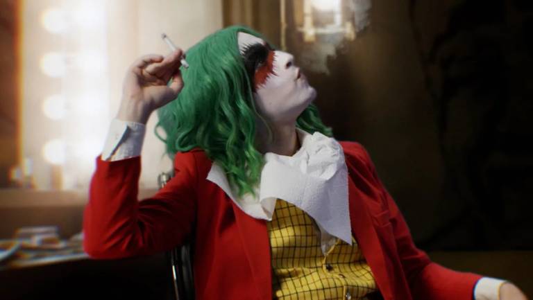 person in joker costume smokes a cigarette