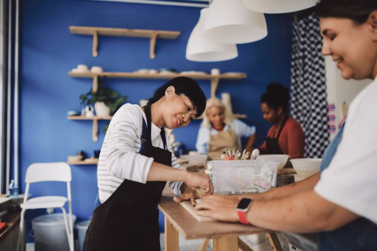 Diverse group of women participating in a creative pottery class at a ceramic studio.